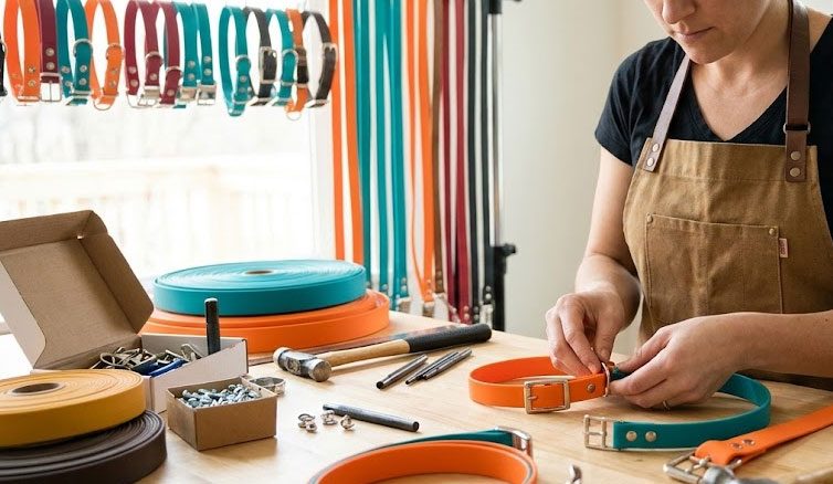 Werkbank mit BioThane-Rollen, Nieten und einer Hand, die ein Halsband schließt